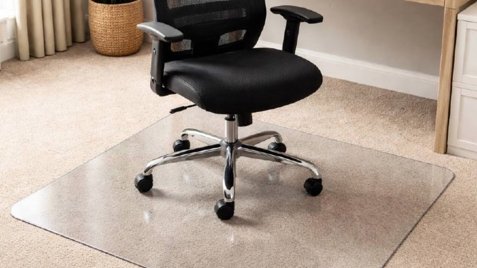 Office chair on a transparent chair mat placed over carpet in a home office